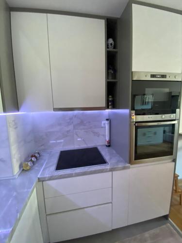 トレビニェにあるAFRIKAの白いキャビネットとカウンタートップを備えたキッチン