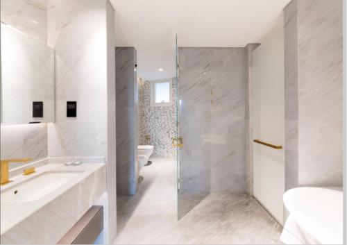 baño blanco con ducha y lavamanos en Five Palm Residences Dubai - 2BR Fully Furnished en Dubái