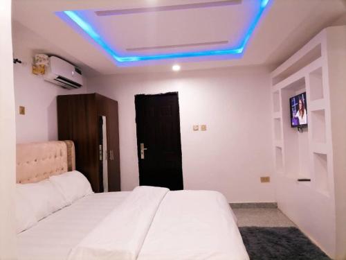 um quarto com uma cama com uma luz azul no tecto em Big Ocean Inn em Ibadan