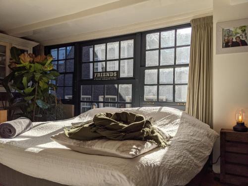 a bed with a blanket on it in a room with windows at LaneStay DamSquare in Amsterdam