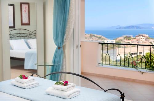 a room with two beds and a balcony with a view at Villa Odyssia in Agios Nikolaos