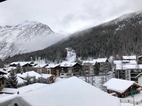a town covered in snow in front of a mountain at Saaserhof Apartments in Saas-Fee