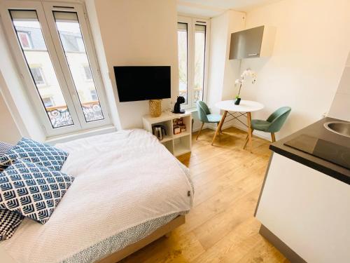 a bedroom with a bed and a table with chairs at Studios meublés Brest Keruscun in Brest
