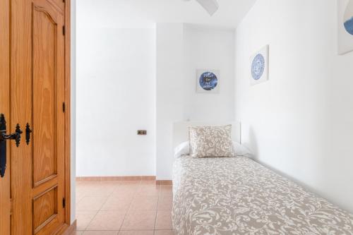 a bedroom with a bed and a wooden door at Apartamento San Juan 18 in Nerja