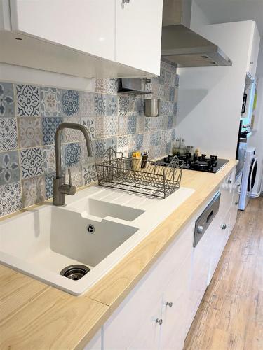 une cuisine avec un évier et un plan de travail dans l'établissement La Maison de Manon, 5mn Zoo de Beauval, à Seigy