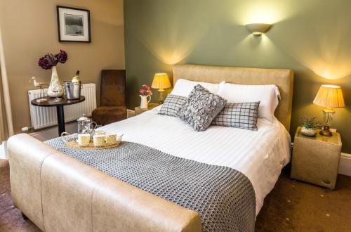 um quarto com uma cama grande e 2 candeeiros em The Lounge Hotel & Bar em Penrith