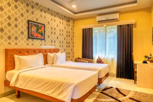 a hotel room with two beds and a window at HOTEL ROYAL GRANDE in Vellore