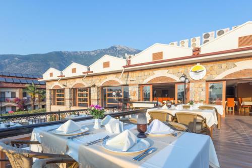 a restaurant with tables and chairs in front of a building at Orka World Hotel & Aquapark in Oludeniz