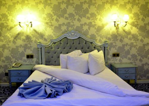 a bedroom with a large white bed with two night stands at Deluxe Hotel Ganja in Ganja