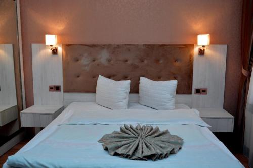 a bedroom with a large white bed with a flower on it at Deluxe Hotel Ganja in Ganja