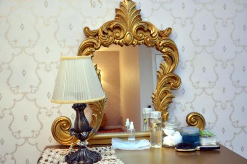 a lamp sitting on a table in front of a mirror at Deluxe Hotel Ganja in Ganja