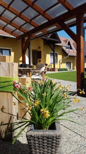 a wicker planter with flowers in a patio at Huber Vendégszobák in Fertőrákos