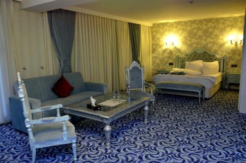 a hotel room with a bed and a couch at Deluxe Hotel Ganja in Ganja