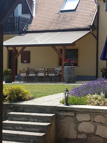 a patio with awning and tables and chairs at Huber Vendégszobák in Fertőrákos