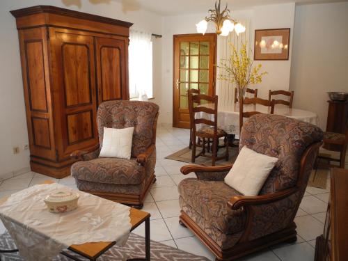 a living room with two chairs and a table at Au Pied du Chateau in Lichtenberg