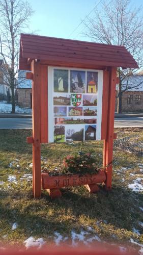a sign in the grass with a bench in it at Ubytovaní Šaslun in Kolešov