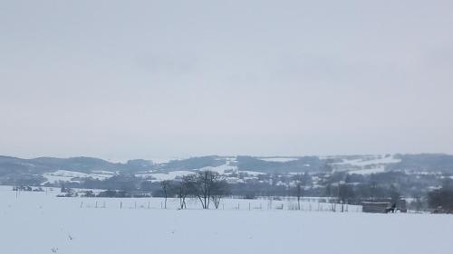 a snow covered field with a town in the distance at Ubytovaní Šaslun in Kolešov