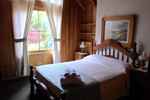 una camera da letto con un letto con due scarpe sopra di Apart Hotel Robles del Sur a San Martín de los Andes