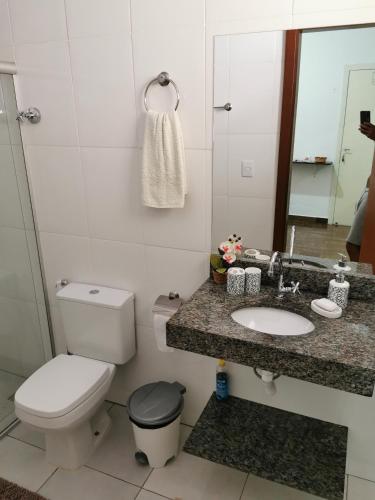 a bathroom with a toilet and a sink and a mirror at Suíte Capitólio in Capitólio
