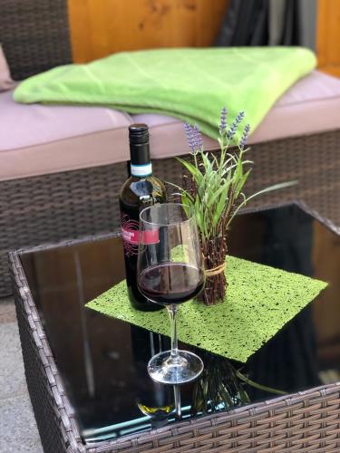 a bottle of wine and a glass on a table at Landhaus Daum in Schwendau
