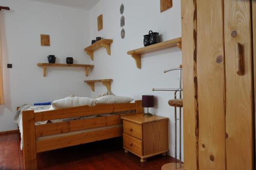 1 dormitorio con cama de madera y estanterías en la pared en APARTAMENT STELLA en Kościelisko
