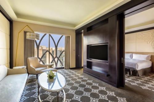 a living room with a couch and a tv and a bed at InterContinental Dhaka by IHG in Dhaka