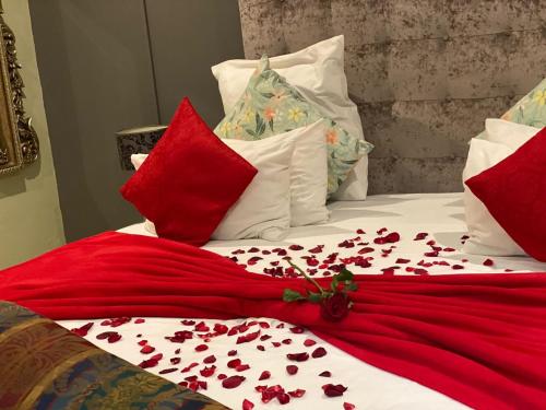 a bed with red and white pillows with roses on it at Marion Lodge in Johannesburg