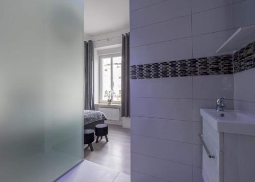 baño blanco con lavabo y ventana en EXECUTIVE DOUBLE ROOM WITH EN-SUITE in GUEST HOUSE RUE TREVIRES R3 en Luxemburgo