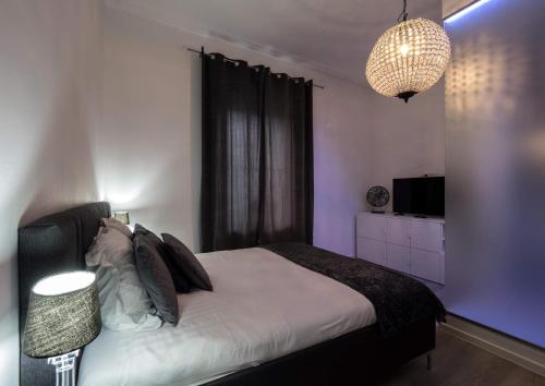 ルクセンブルクにあるEXECUTIVE DOUBLE ROOM WITH EN-SUITE in GUEST HOUSE RUE TREVIRES R3のベッドルーム1室(大型ベッド1台、シャンデリア付)