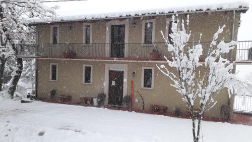 a house in the snow with a tree at Masseria boutique b&b in Montella