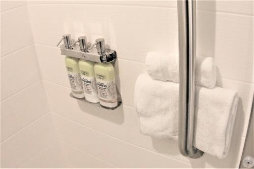box doccia con due bottiglie di sapone e asciugamani di Holiday Inn Express & Suites Cheney, an IHG Hotel a Cheney
