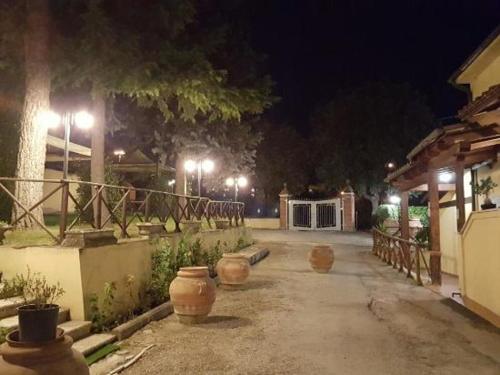 a street at night with some vases on the ground at Hotel Collina di San Sisto in San Sisto