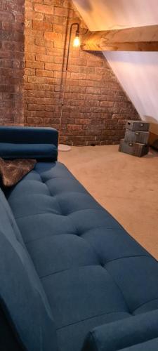 a large blue bed in a room with a brick wall at Ty Morgan's in Rhayader