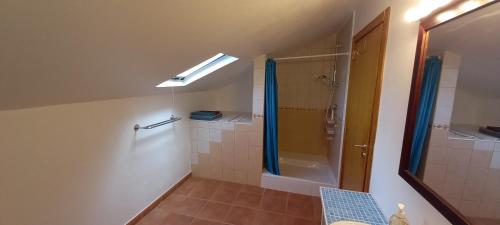 La salle de bains est pourvue d'une douche et d'un rideau de douche. dans l'établissement Quinta Do Centro, à Melriça
