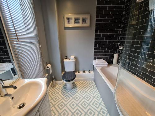 a bathroom with a tub and a toilet and a sink at Ty Morgan's in Rhayader