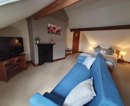 a large living room with a blue couch and a tv at Ty Morgan's in Rhayader