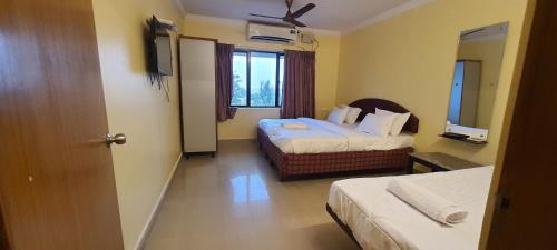 um quarto de hotel com duas camas e uma janela em Royal Stay em Visakhapatnam
