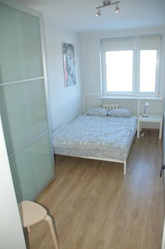 1 dormitorio con cama, silla y espejo en Mieszkanie 2 pokojowe z widokiem na morze, en Gdansk