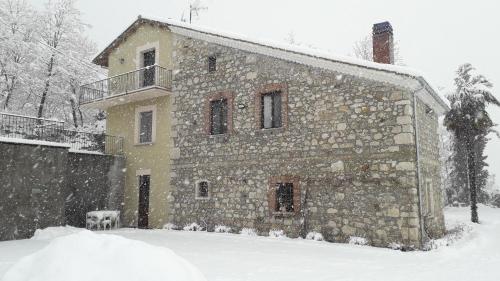 a stone building with a dog standing in the snow at Masseria boutique b&b in Montella