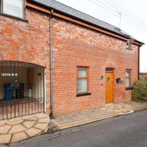 a brick building with a gate in front of it at Mews Cottage Bangor in Bangor