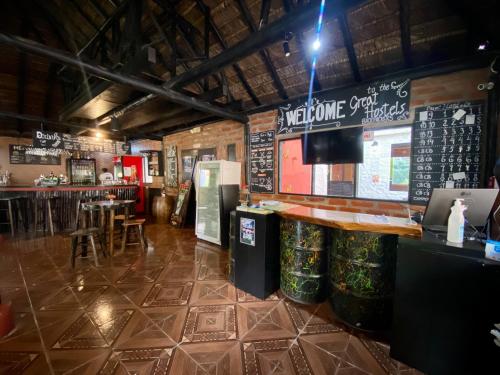 a restaurant with a bar and a counter with beer cans at Great Hostels in Baños