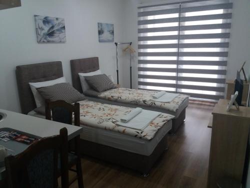 Una cama o camas en una habitación de Apartments Karić Aerodrom Tuzla