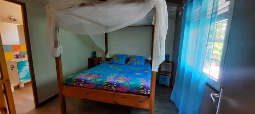 a bedroom with a bunk bed with a canopy at Gîte "Avocatier" in Bouillante