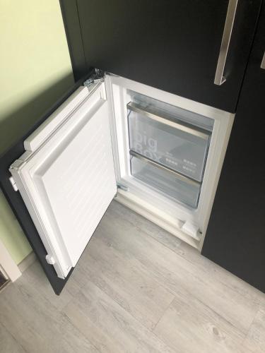 an open refrigerator door with a window in a kitchen at Ferienwohnung Osterfeld in Osterfeld