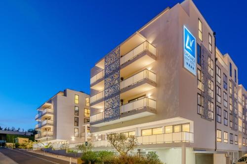 a building with a sign on the side of it at Lagrange Apart'Hôtel Antibes Olympie in Antibes