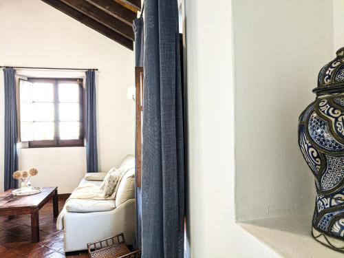 a living room with a couch and a vase at Hotel Fuente del Sol in Antequera