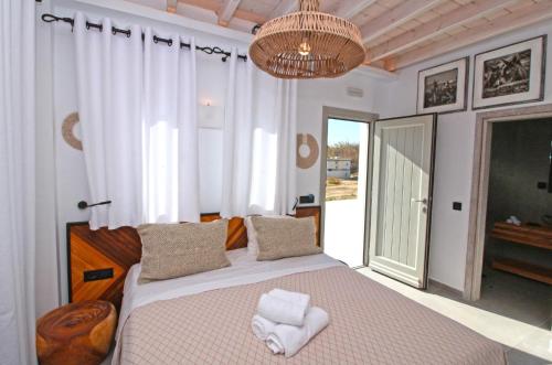 a bedroom with a large bed and a chandelier at Enalion Suites in Mikonos