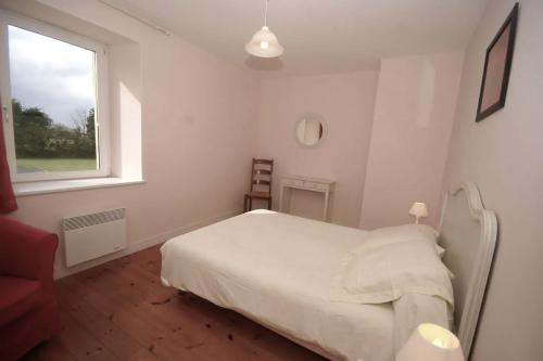 une chambre blanche avec un lit et une fenêtre dans l'établissement La Grange, à Maisons
