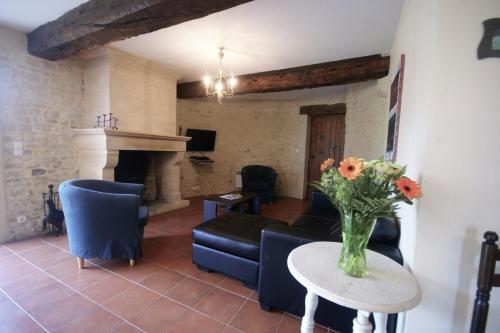 un salon avec un vase de fleurs sur une table dans l'établissement Le Pressoir, à Maisons