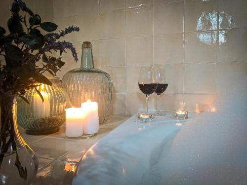 a table with two glasses of wine and candles at Hotel Fuente del Sol in Antequera